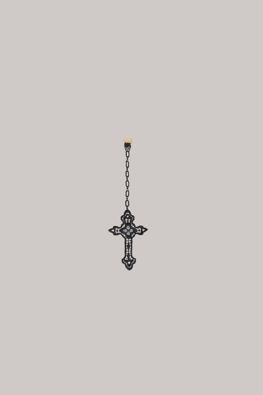 A crocheted cross on  grey background.