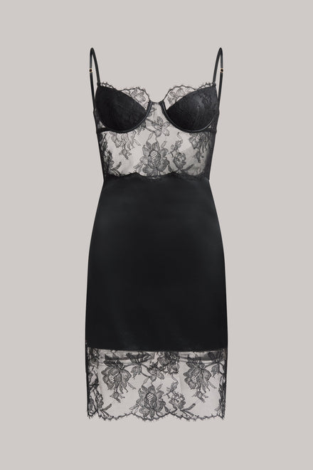 A black satin slip dress with black lace cups and floral lace hem, displayed on a neutral gray background.