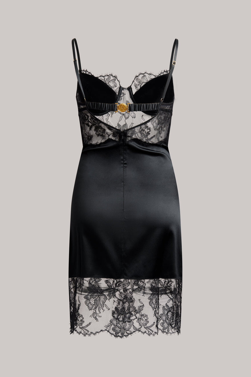 Black satin slip dress with lace details on a gray background