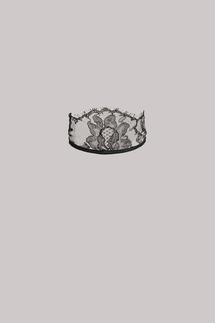 Black lace neck piece on a grey background.