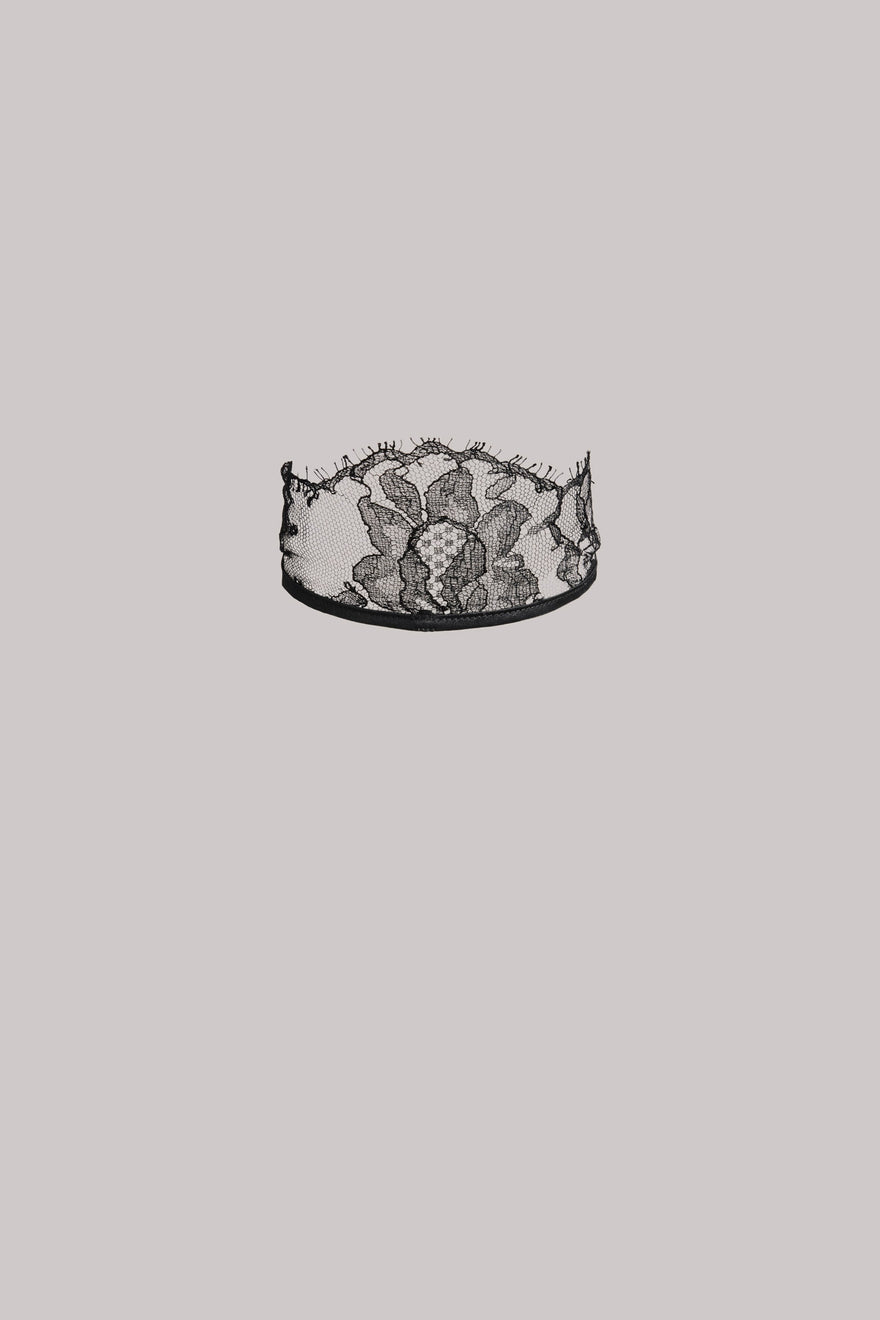 Black lace neck piece on a grey background.