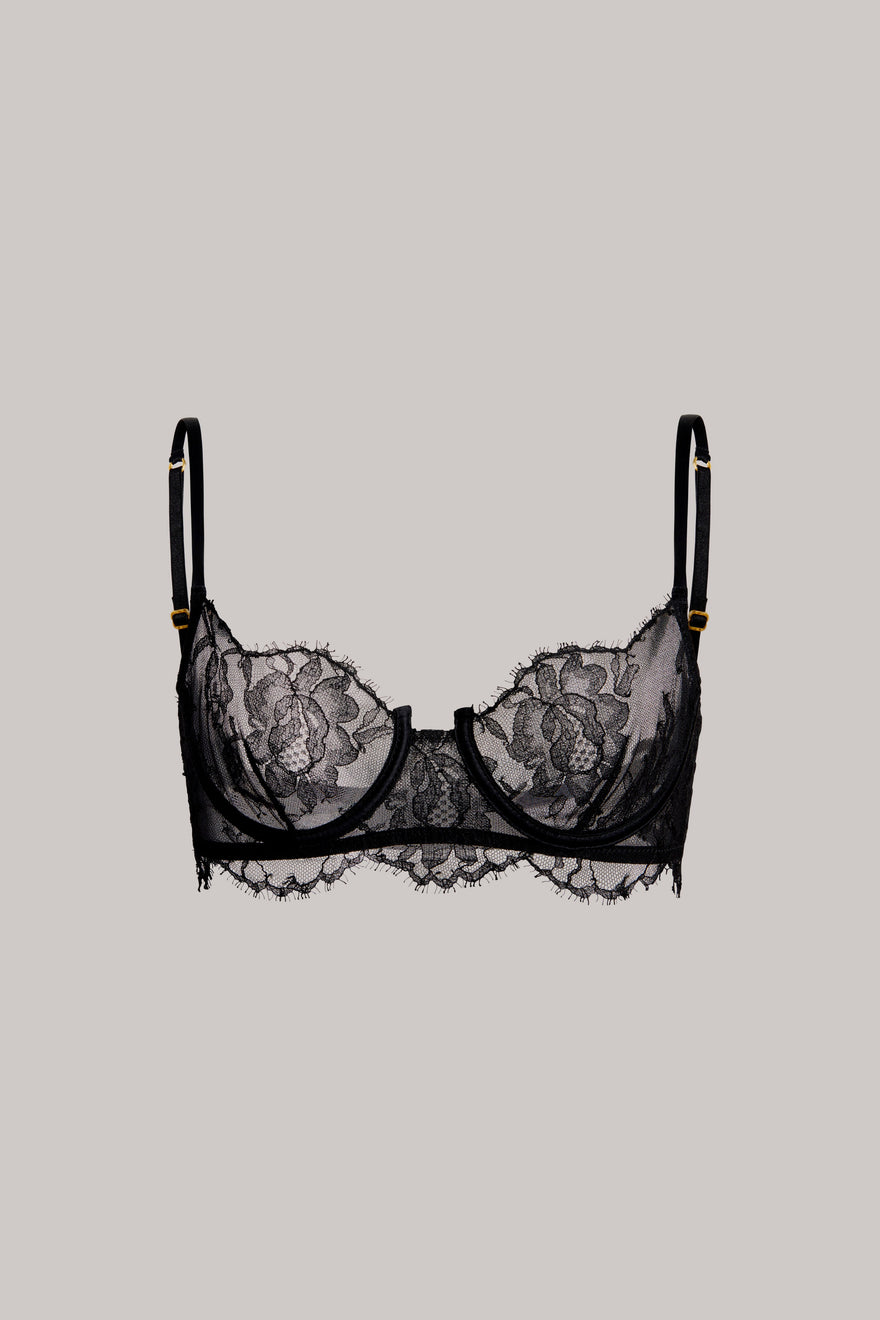 Black lace underwire bra with floral lace cups and thin adjustable shoulder straps, shown flat against a solid light gray background.