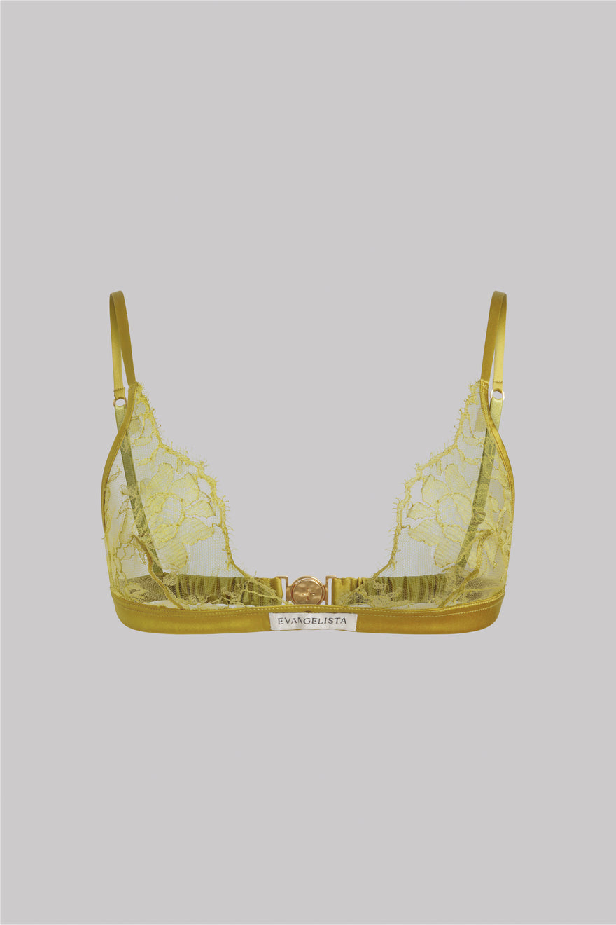 A yellow lace bralette with a gold trim and a small white brand label that reads 'EVANGELISTA' on a solid gray background.