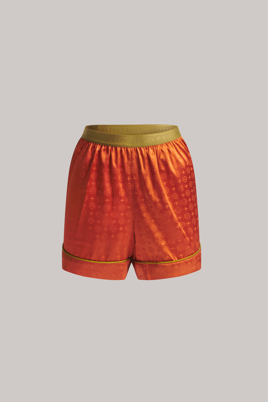 Orange shorts with a green waistband on a gray background