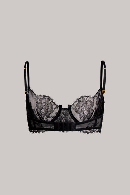 Black lace underwire bra with floral lace cups and thin adjustable shoulder straps, shown flat against a solid light gray background.