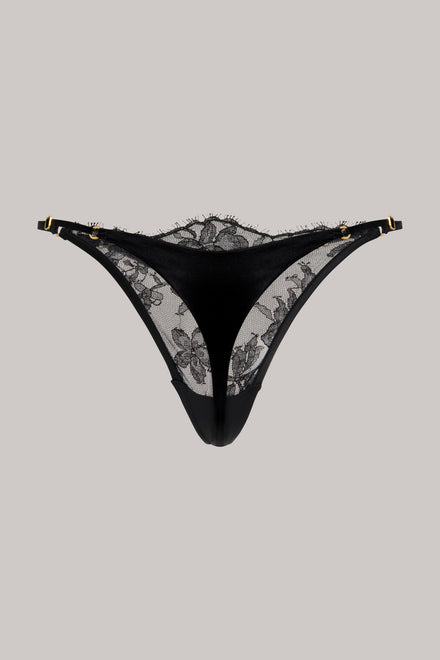 Black lace thong underwear with gold-tone hardware, displayed flat against a solid light gray background.