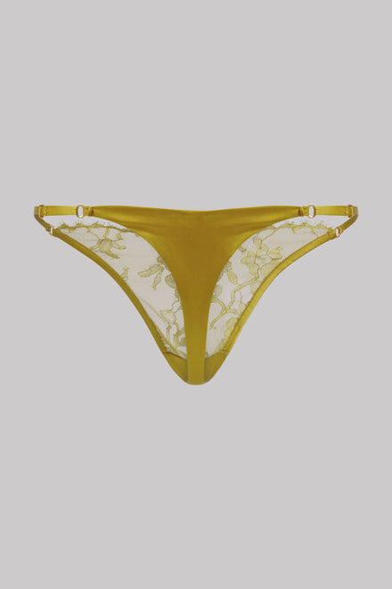 A pair of women's thong-style underwear in a mustard yellow color, featuring sheer floral lace panels on the inner side and matching elastic waistband, shown against a solid gray background.