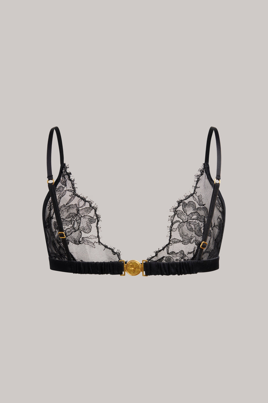 Black lace underwire bra with gold decorative accents and adjustable shoulder straps, shown flat against a solid light gray background.