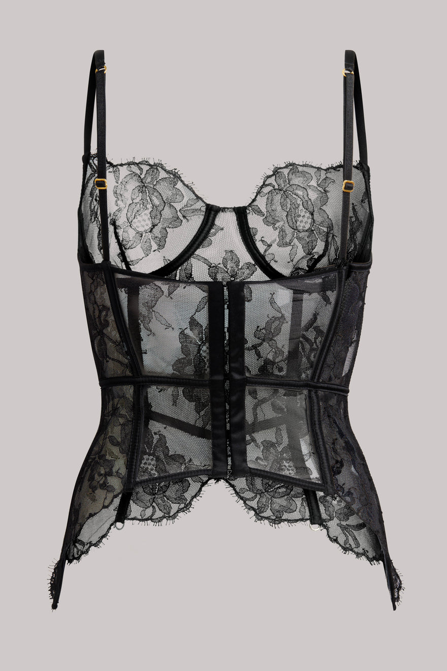 Black lace and mesh corset-style lingerie top with floral lace cups, sheer panels, thin shoulder straps, and a center front closure, shown against a plain light gray background.