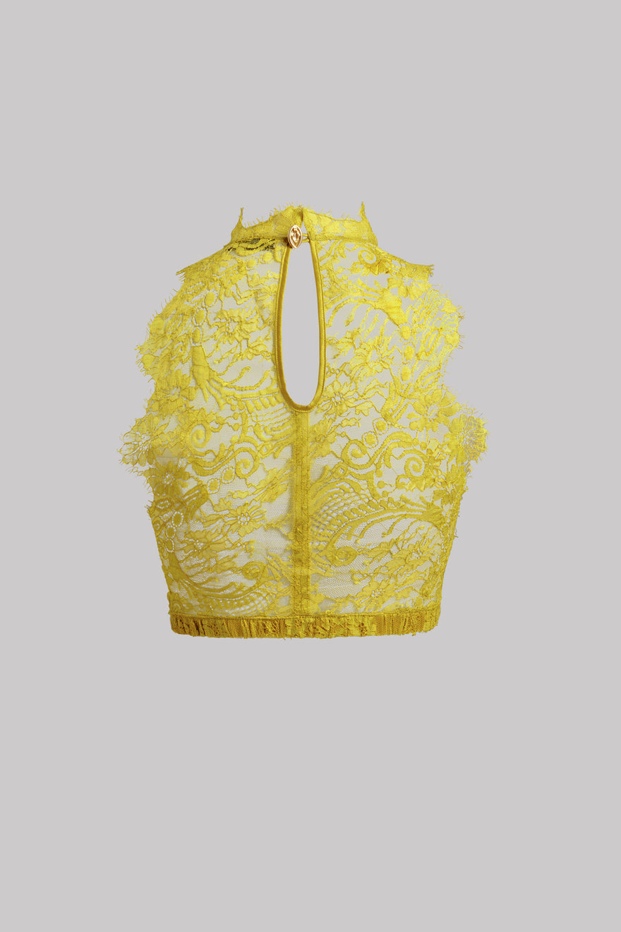 A yellow lace halter crop top with a keyhole cutout and gold-tone zipper, shown against a solid gray background.