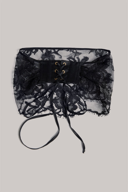 Black lace eye veil with a central lace-up front and long ties, shown flat on a light gray background.