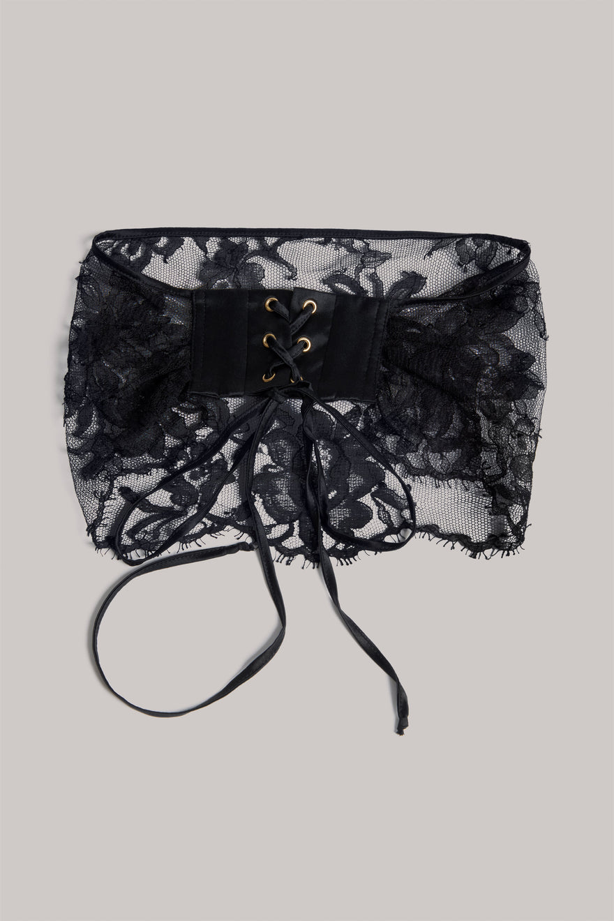 Black lace eye veil with a central lace-up front and long ties, shown flat on a light gray background.